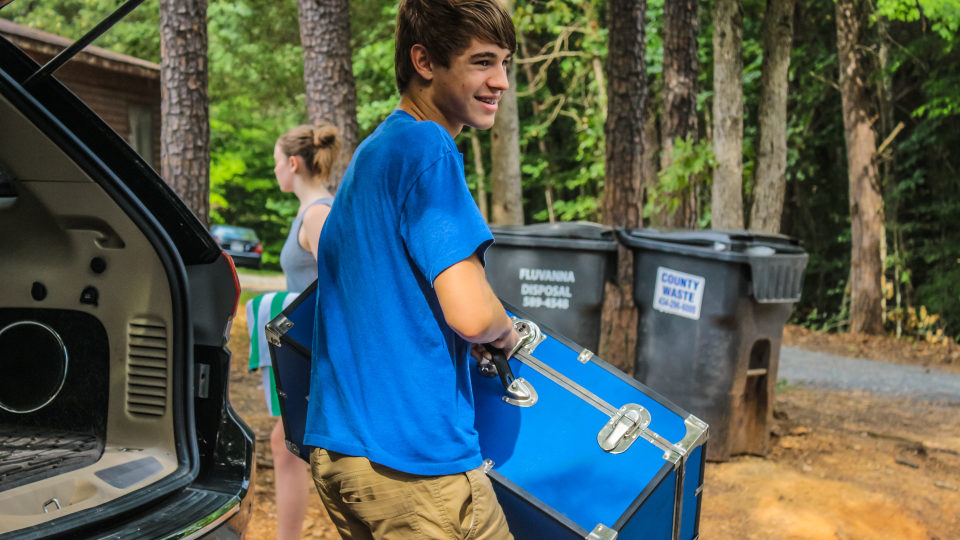 One of our Counselors In Training unpacks his blue trunk, perfect for storing all he needs for a overnight residential camp.