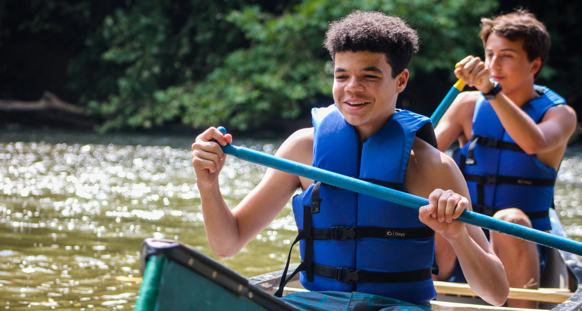Two teen boys enjoy canoeing at Camp Friendship