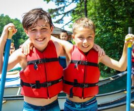 two kids canoeing and making friends at camp