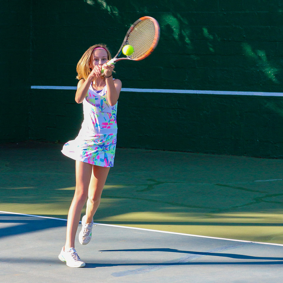 Young girl camper hits a tennis ball at Camp Friendship Tennis program for kids and teens