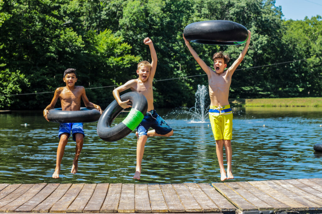Three boy campers enjoy Friendship Lake at Camp Friendship