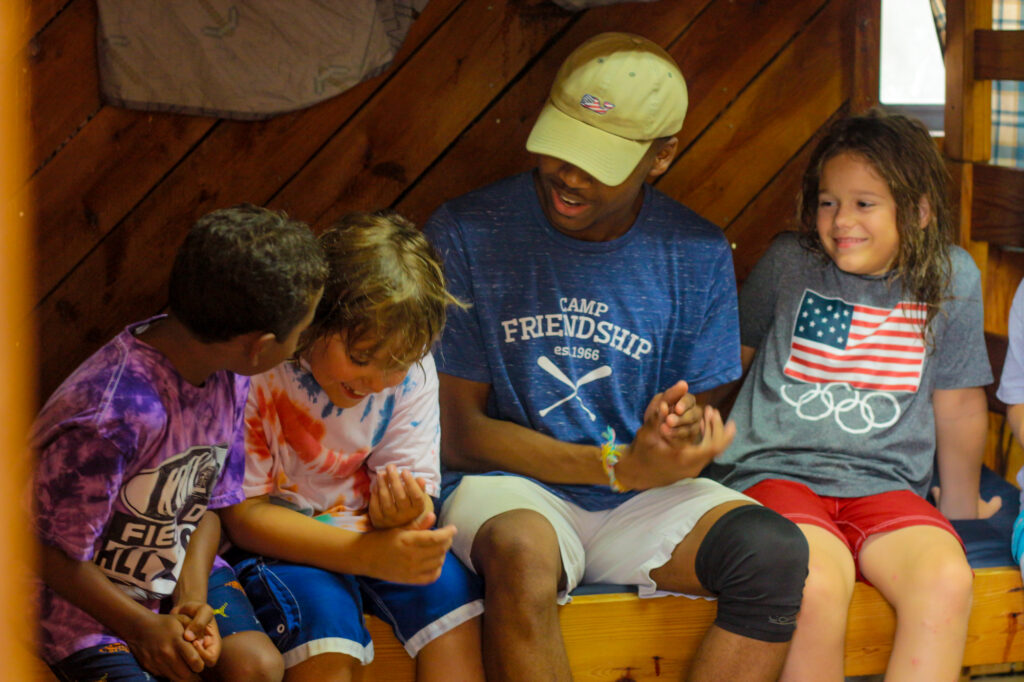 Three Junior Boy campers and a Counselor bonding during Village time