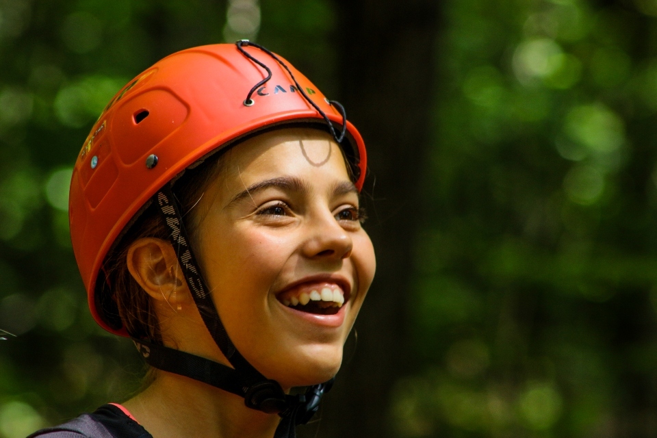 Teen Camper smiles while at the High Ropes course at a coed overnight camp in Virginia  