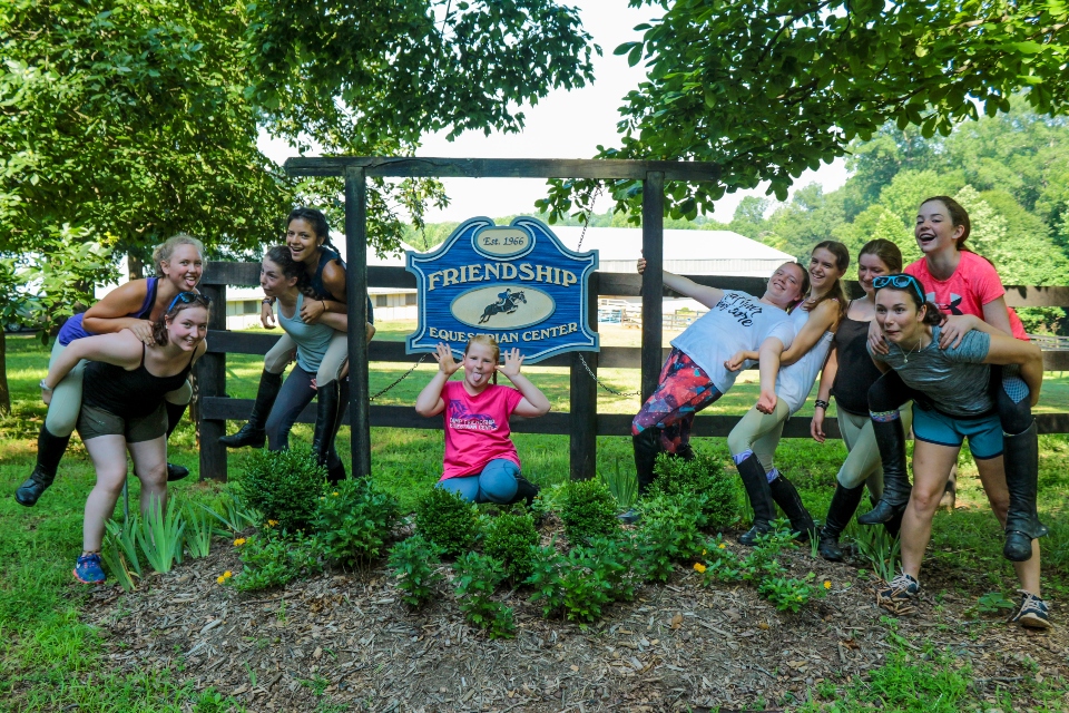 Equestrian Campers pose in front of the Equestrian Center sign at Camp Friendship sleep-away camp