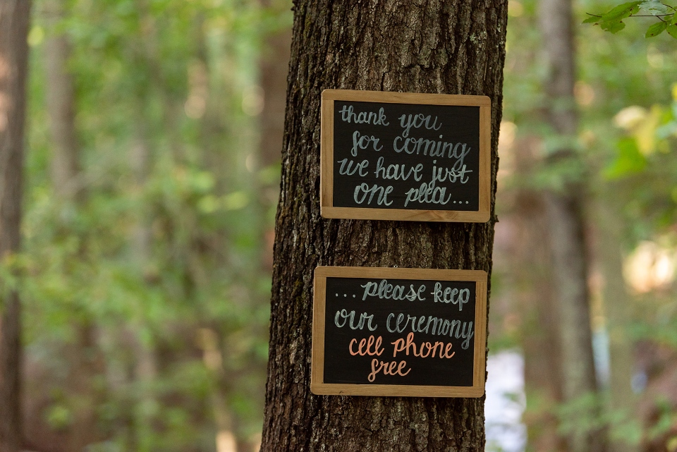 Chalkboard signs give directions and instructions to a wedding party that the ceremony will be cell phone free.