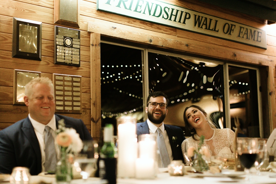 A happy groom and bride enjoy their first meal as a married couple with the friendship wall of fame in the background. 