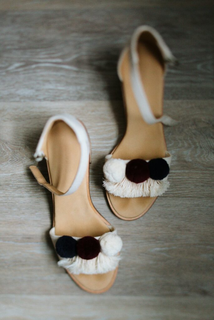 A pair of fancy, and heeled, sandels show the mix of outdoors and style available at a outdoor camp wedding.