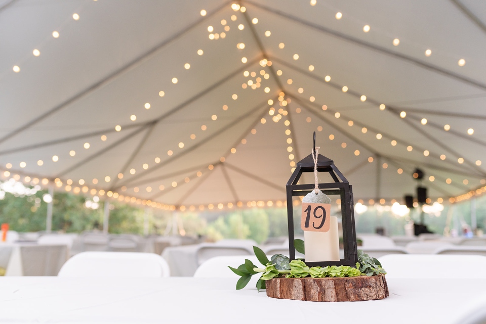 A wedding tent strung with lights is shown, a beautiful camp wedding venue atop our mountain boarding hill.