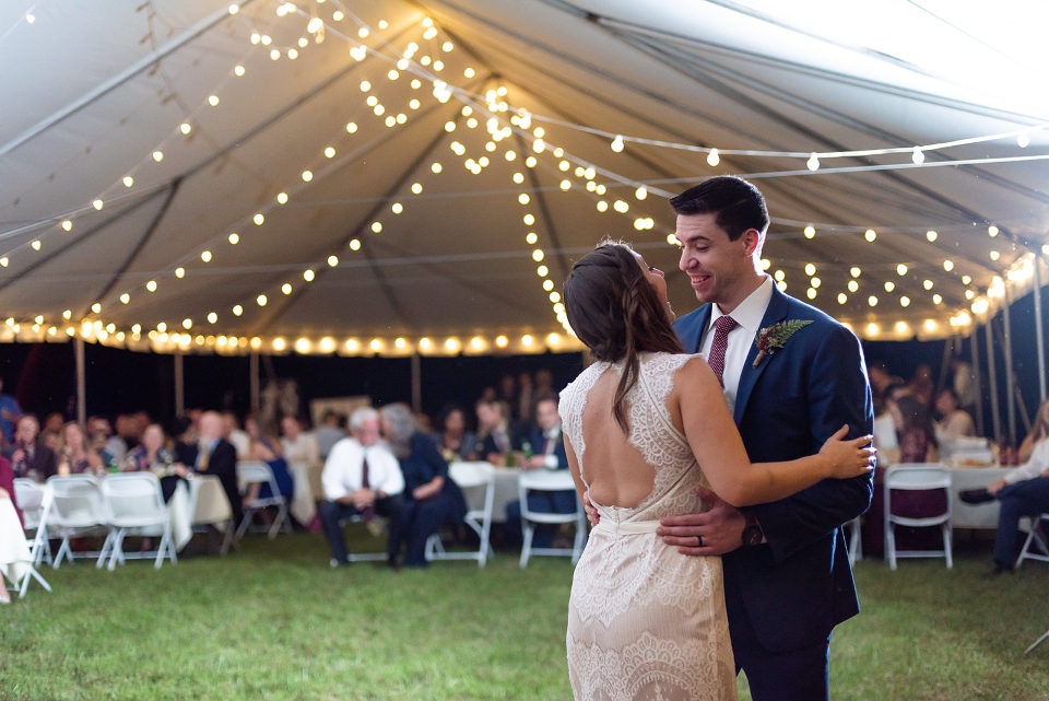 Couple dancing under a wedding tent filled with lights at our outdoor camp wedding venue in Virginia.