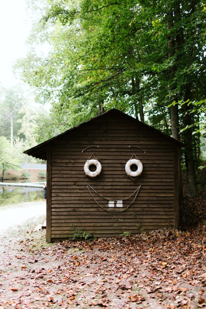 Sid the shed smiles next to camp friendship lake. He contains all of our boating supplies.