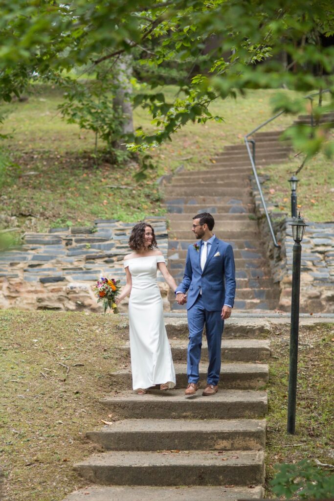 Bride and Groom walking down stone stairs hand in hand