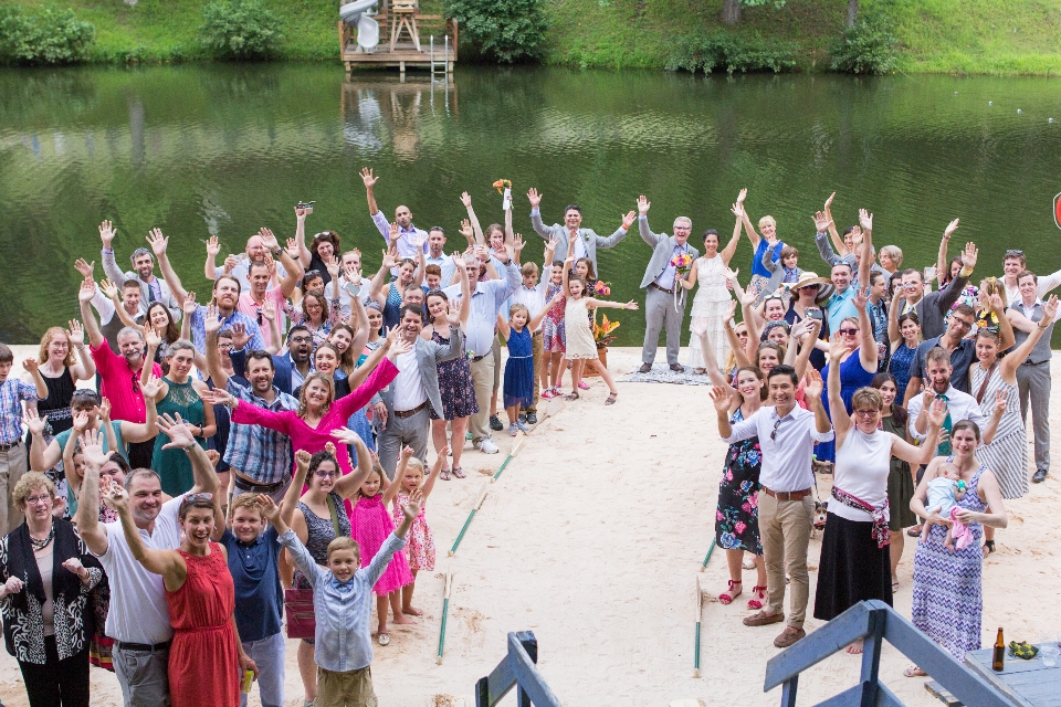 Wedding party celebrating bride and groom on beach at Camp Friendship Virginia wedding venue