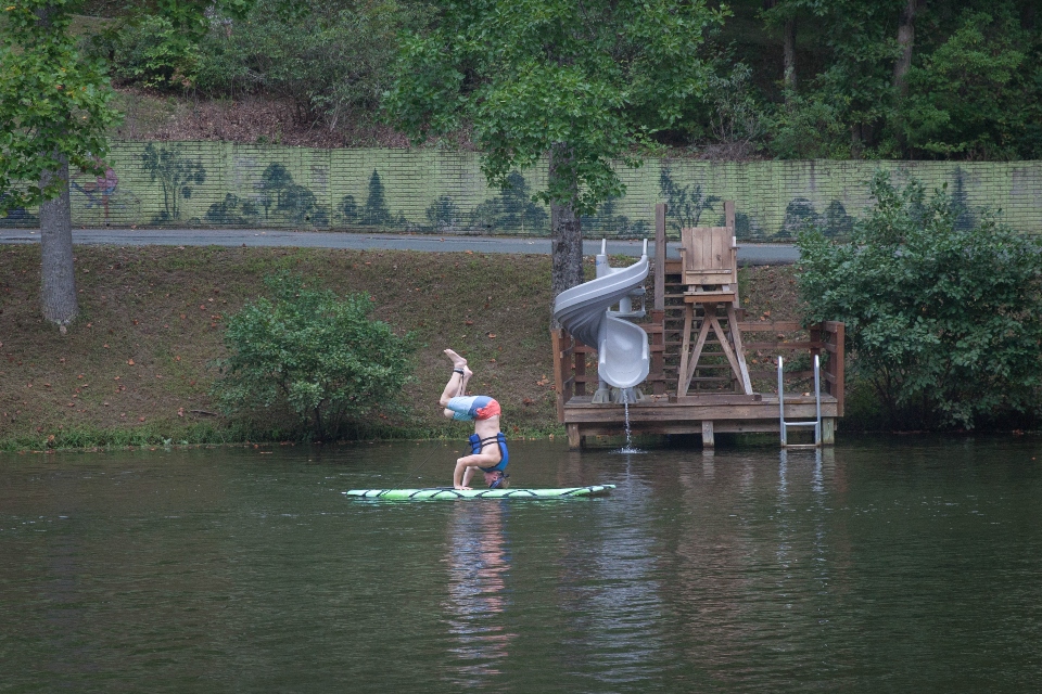 Man in a handstand position doing yoga on a paddle board in Friendship lake