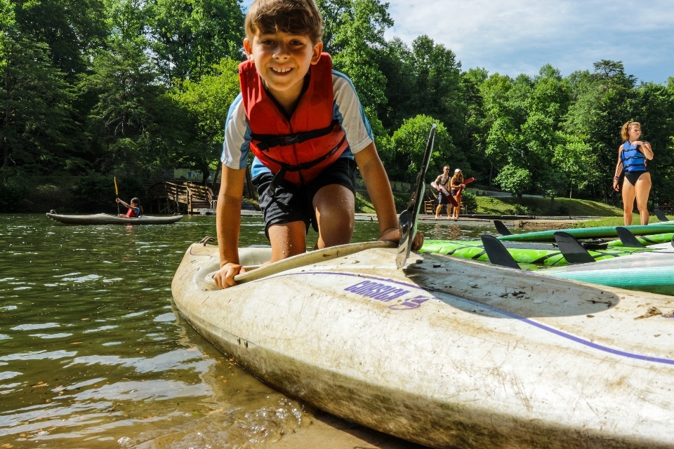 Young boy camper gets ready to kayak at overnight camp in Virginia