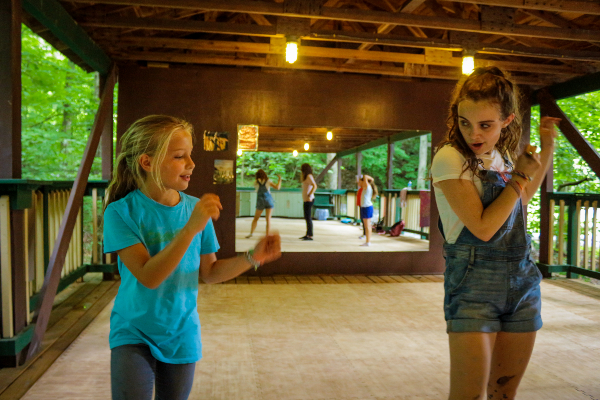 counselor teaches young camper dance moves at coed overnight camp in Virginia