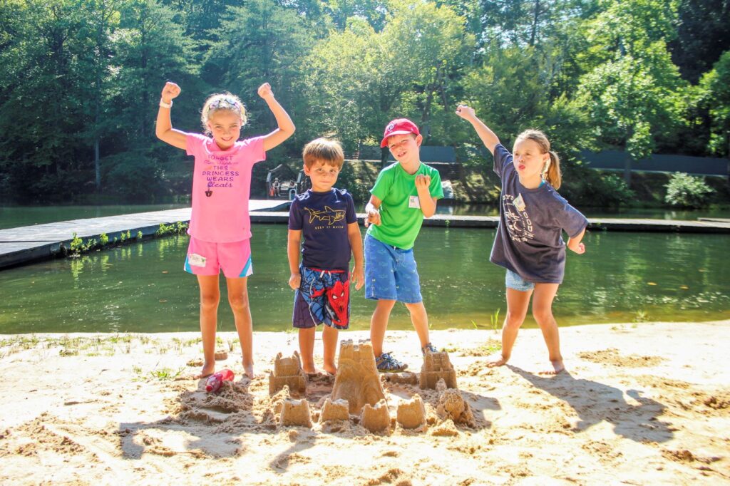Campers making sandcastles by the lake
