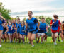 A group of kids in blue jerseys running while playing Capture the Flag.