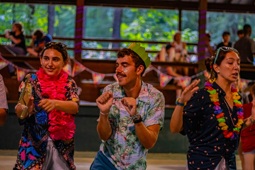 Line of 3 people dancing with tropical shirts on