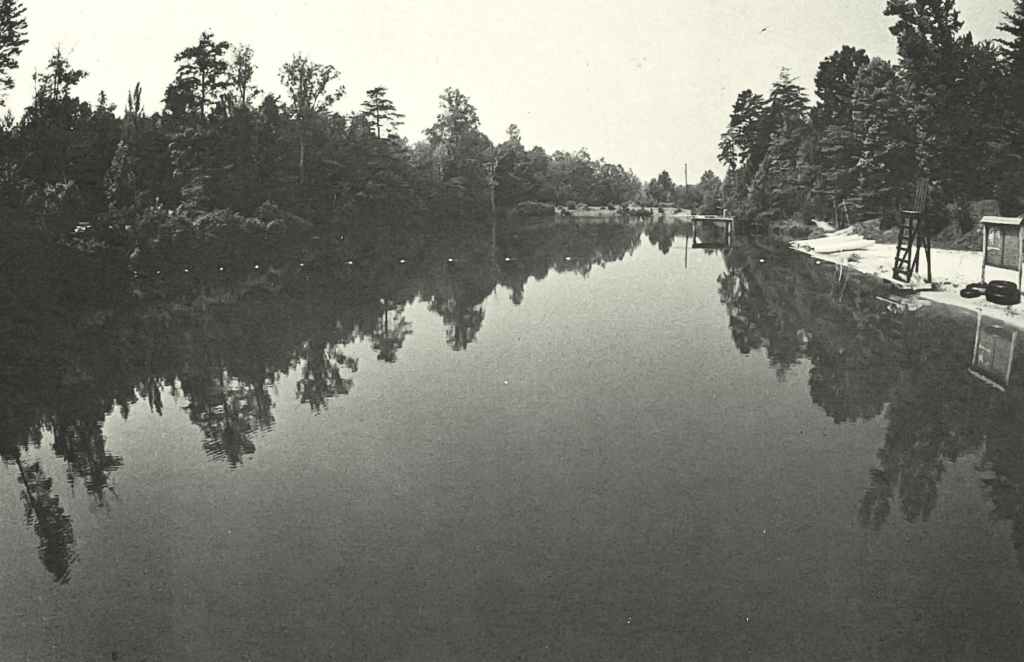 A black-and-white photo of a swimming lake at camp